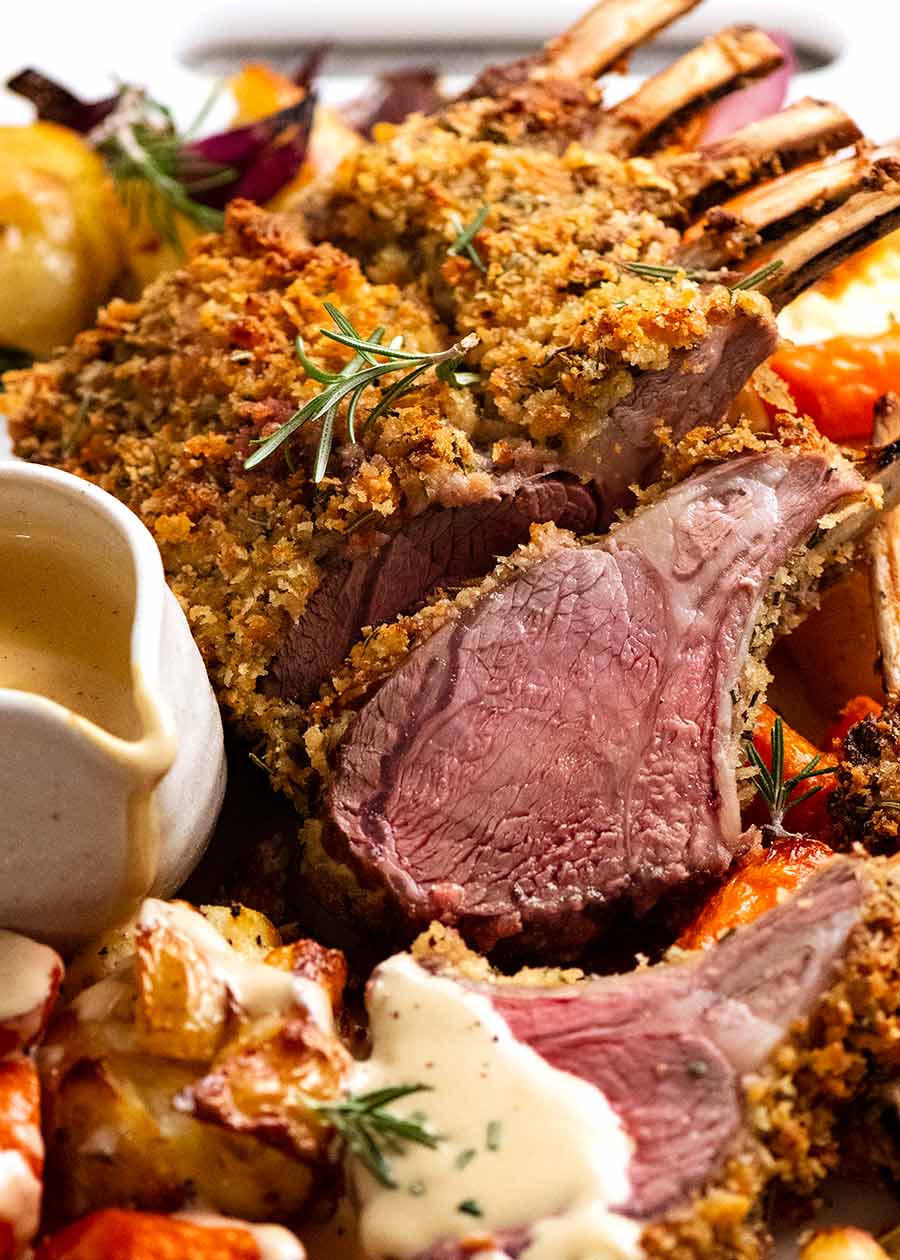 Rosemary Crumbed Rack of Lamb on a platter with roasted vegetables