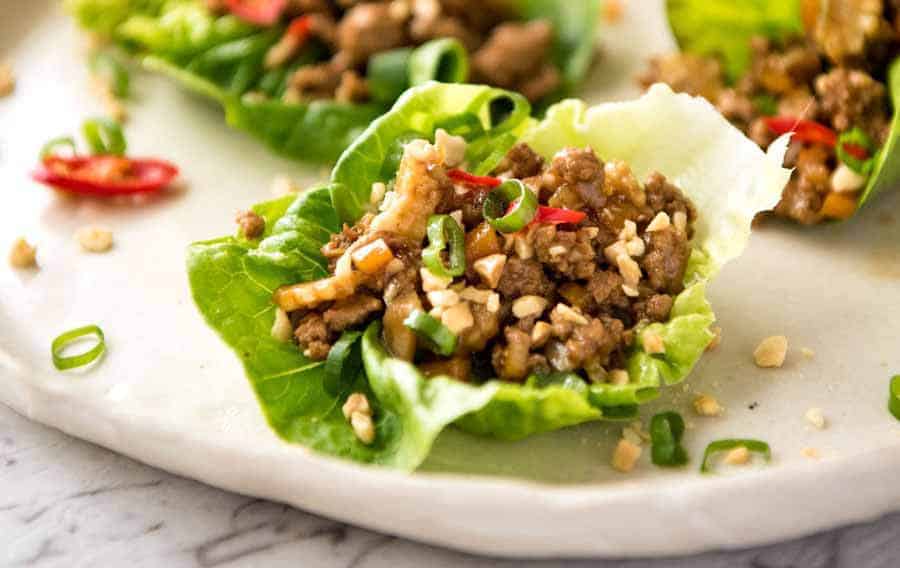 Close up of Chinese Lettuce Wrap being held by a hand, about to be eaten