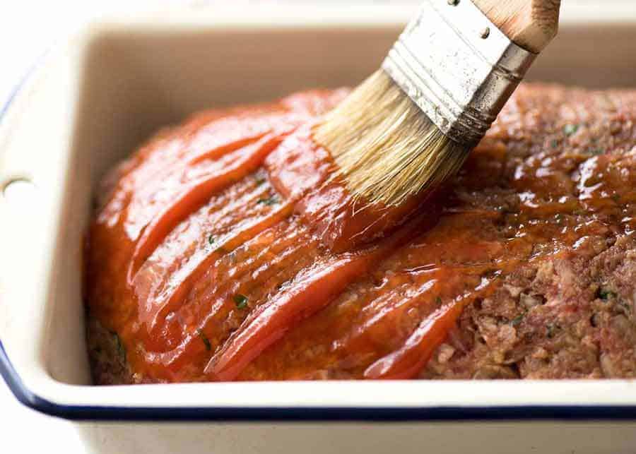 Brushing glaze on meatloaf in pan